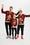 En mand, en dame og et barn poserer sammen, hver iført en mørkerød julesweater med kagepersoner og julemønster på.