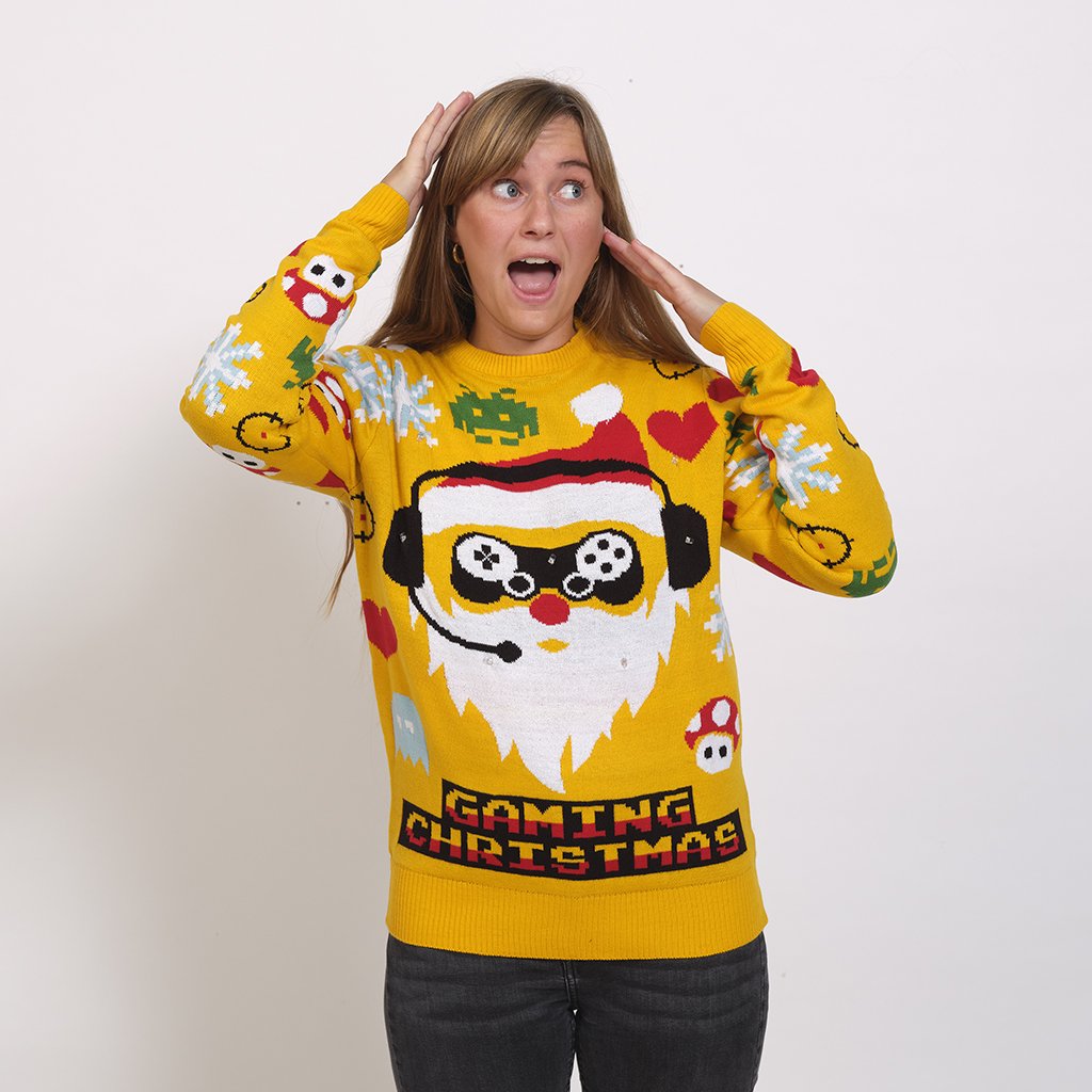 Une femme portant un pull de Noël jaune avec un lutin joueur dessus.