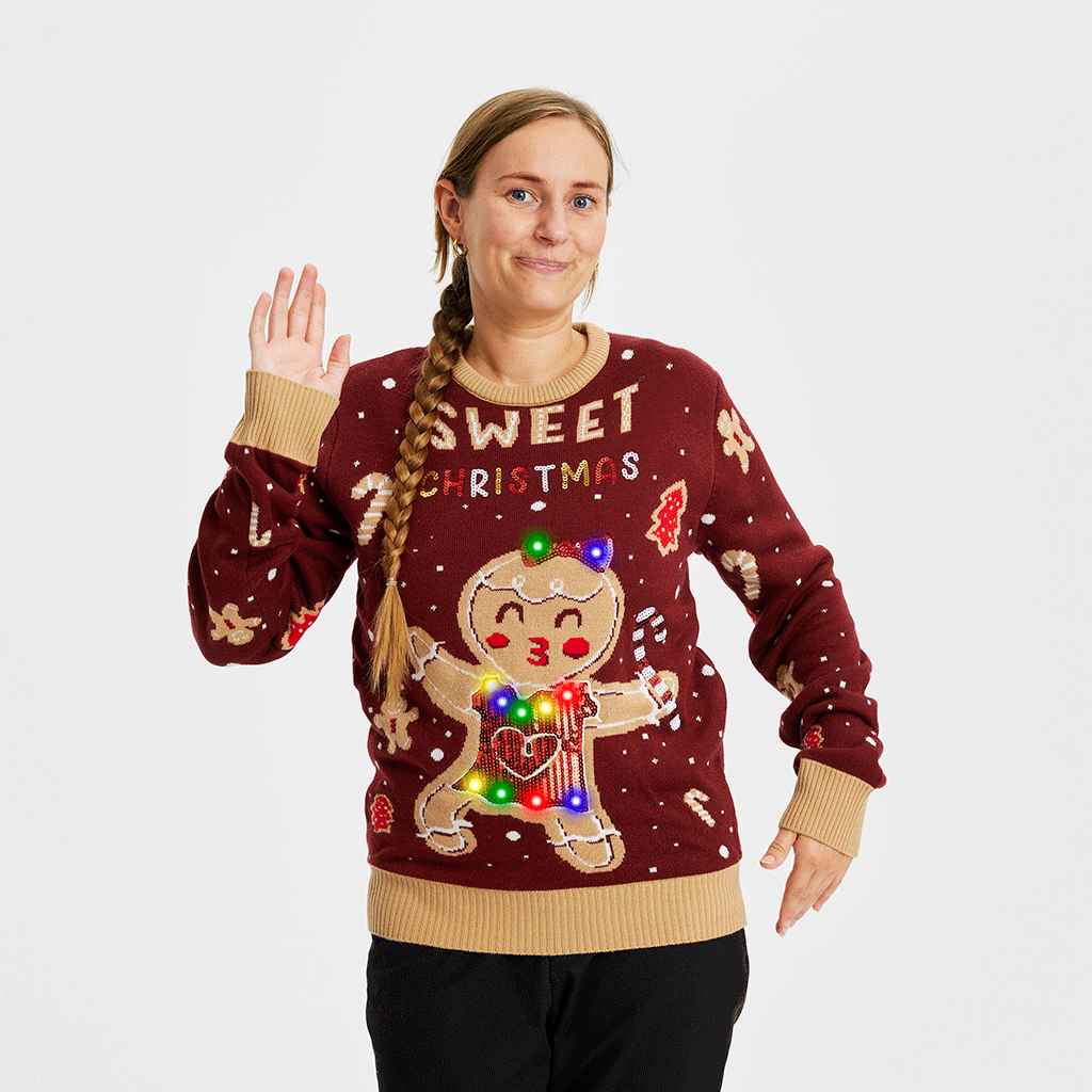 Une femme portant un pull rouge de Noël avec un panier de biscuits.