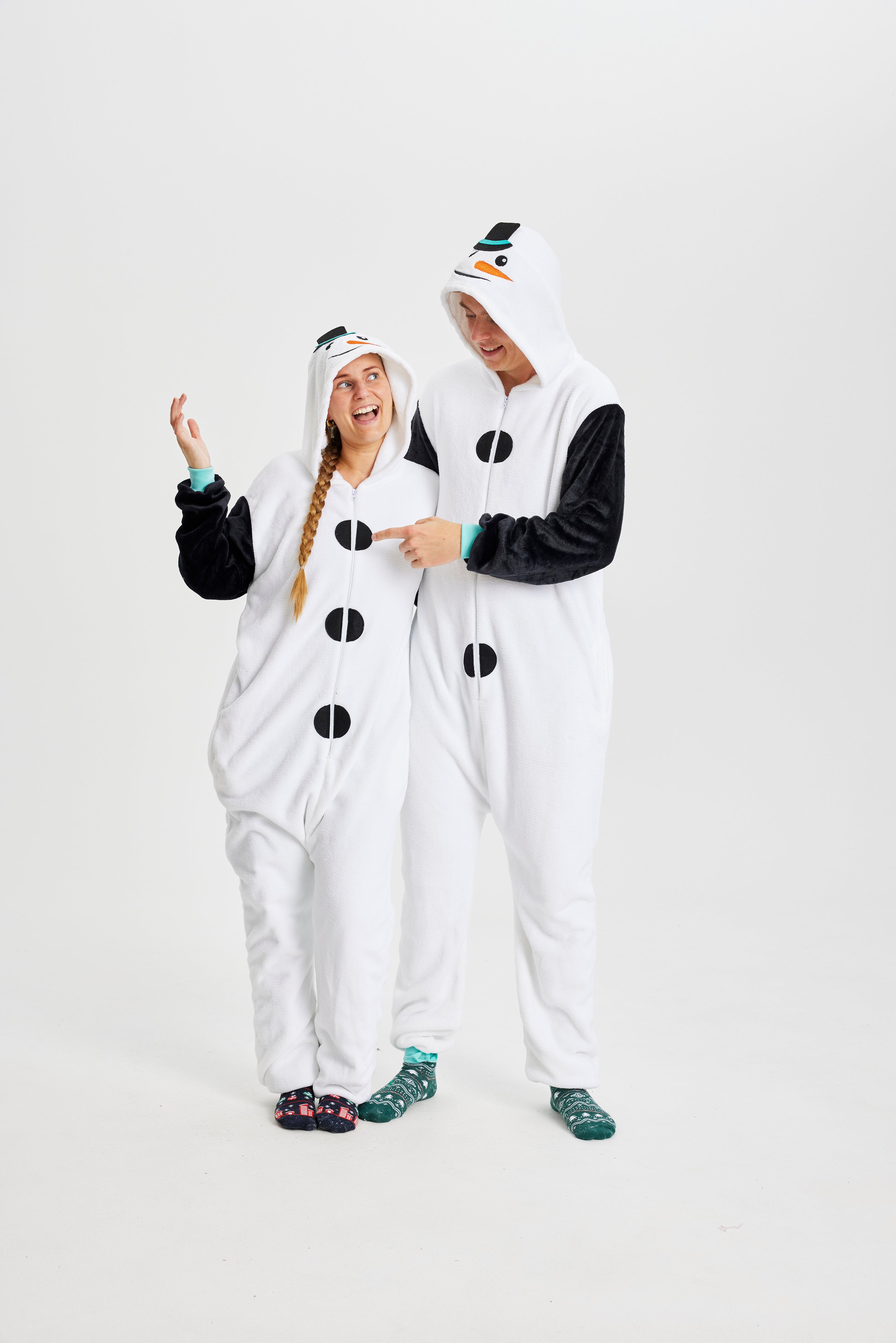 En mand og en kvinde i hvide jumpsuits, der ligner snemænd.