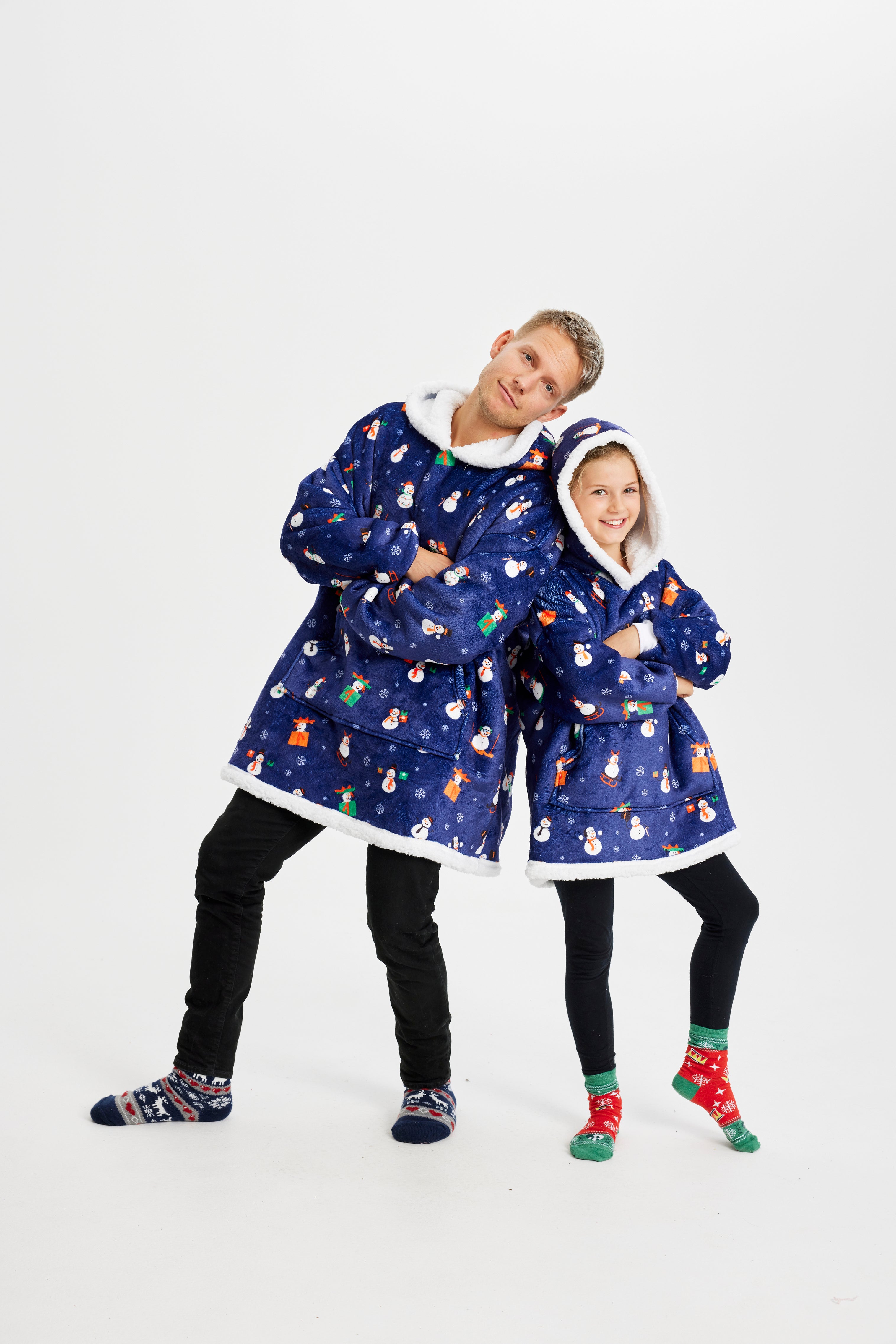 Un enfant et un homme portent un sweat à capuche bleu avec un motif de Noël.