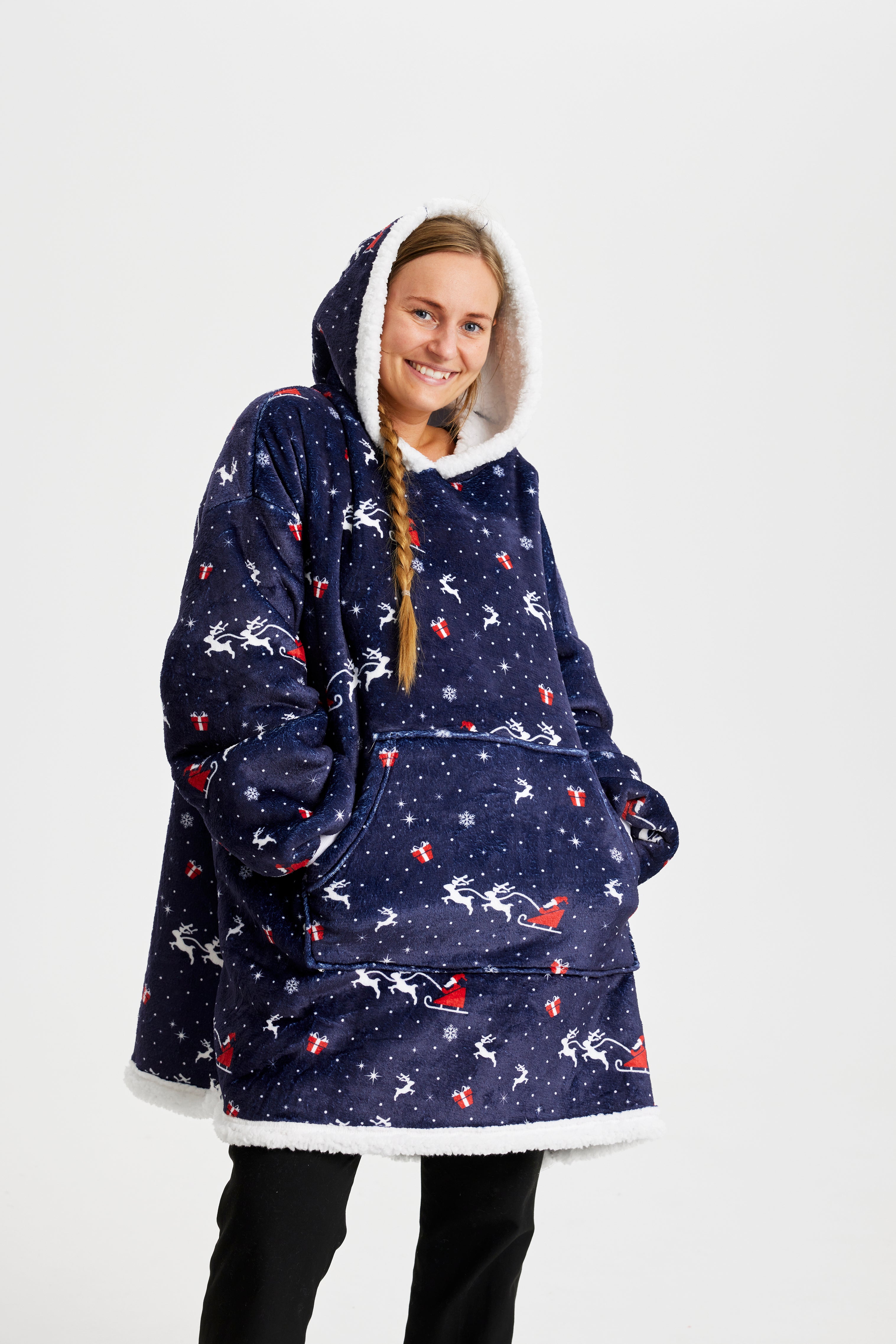 Une femme souriante portant un sweat de Noël bleu foncé.