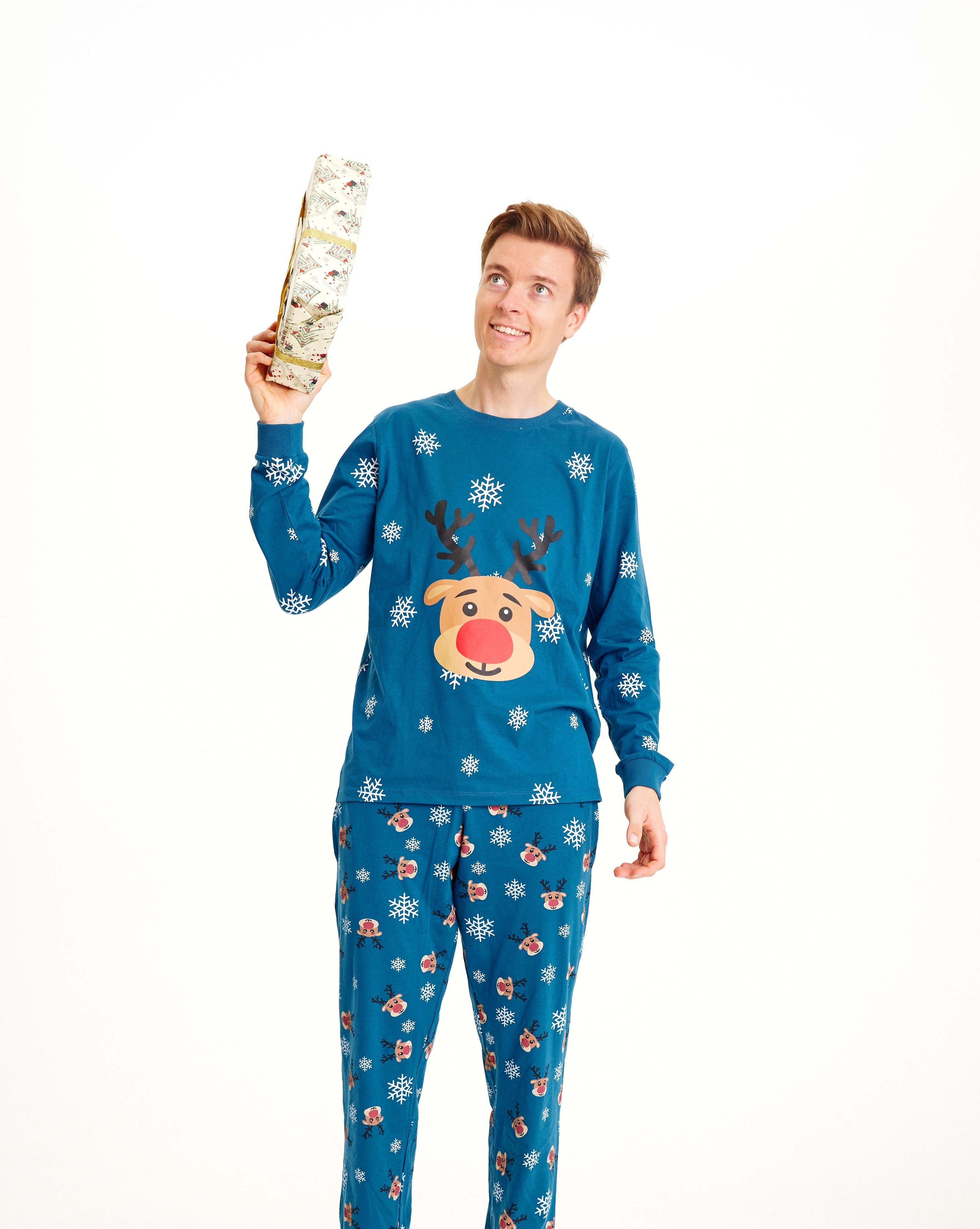 Un homme portant un pyjama de Noël bleu orné de Rudolph.