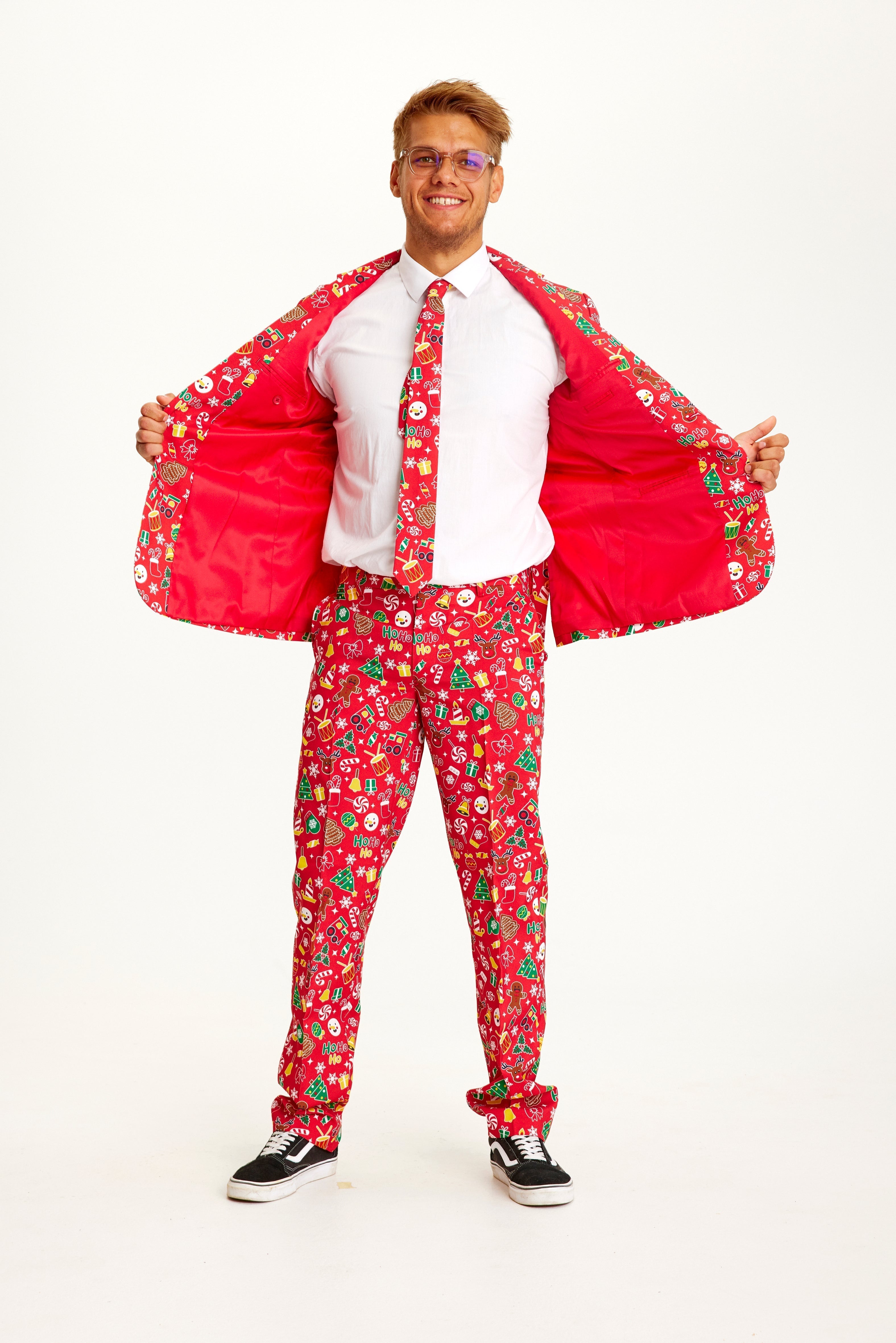 Un homme posant portant un costume de Noël rouge.